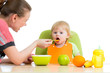 mother spoon feeding her baby girl