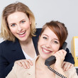Two business women work in the office as a team