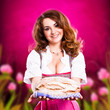 junge Frau im Dirndl bietet ein Brot an