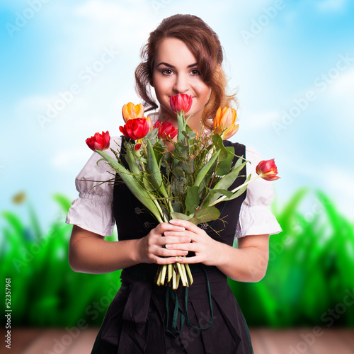 Photo: junge Frau im Dirndl mit einem Strauß Tulpen junge Frau im Dirndl mit einem Strauß Tulpen