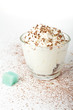 White cup of whipped cream with chocolate, on a white background