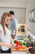 Woman enjoying cooking with man watching