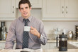 Man drinking coffee while reading newspaper