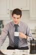 Photo: Man turning the page while drinking coffee Man turning the page while drinking coffee