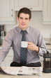 Man reading newspaper while drinking coffee