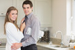 Man with a newspaper under his arm hugging his wife