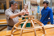 Two students and an explaining teacher in a woodwork class