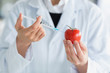Foto: Woman injecting liquid in tomato Woman injecting liquid in tomato