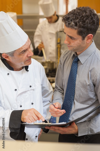Photo: Chef and waiter having a discussion Chef and waiter having a discussion