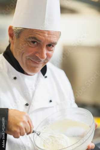 Photo: Smiling chef whisking cream Smiling chef whisking cream