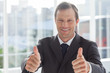 Smiling businessman giving thumbs up