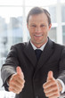 Smiling confident businessman giving thumbs up