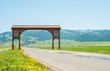Beautiful countryside road with a wood carved gateway