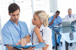 Two doctors talking about a blue file