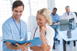 Photo: Two smiling doctors talking about a blue file Two smiling doctors talking about a blue file