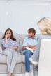 Troubled couple sit with arms folded
