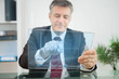 Businessman using futuristic touchscreen to view graph