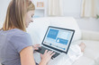 Foto: Woman sitting on couch and checking social media profile Woman sitting on couch and checking social media profile