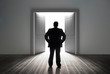 Photo: Businessman looking at door showing bright light Businessman looking at door showing bright light
