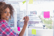 Woman drawing on flowchart with marker and smiling at camera
