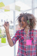 Woman with check shirt drawing on flowchart with marker