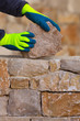 Photo: Mason hands working on masonry stone wall Mason hands working on masonry stone wall