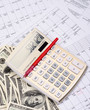 calculator with pen and dollars