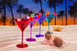Photo: colorful cocktail in a row cherry on sand palm trees colorful cocktail in a row cherry on sand palm trees
