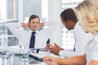 Businessman relaxing while listening to colleagues