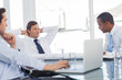Confident businessman relaxing while listening to colleagues