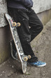 Skater leaning against wall with his board