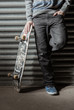Skater standing against metal shutters