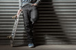 Skater leaning against metal shutters