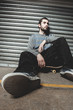 Skater sitting on his board taking a break