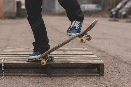 Photo: Skater doing manual trick on wooden crate Skater doing manual trick on wooden crate