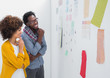 Cheerful designers standing in front of material samples