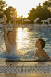 Activities on the pool. Cute boys swimming and playing in water