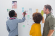 Team of designers pointing at a group of photos