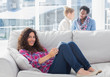 Smiling worker using tablet pc while laying on a couch