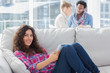 Happy worker using tablet pc while laying on a couch