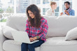 Concentrated worker using laptop while sitting on a couch