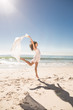 Pretty young woman jumping on the beach