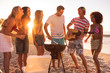 Group of friends playing guitar on the beach