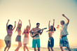 Friends playing guitar on the beach