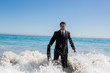 Cheerful businessman walking in the sea