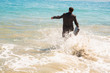 Happy businessman running into the sea