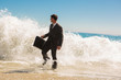 Businessman walking at the edge of the sea