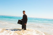 Businessman standing in the sea 