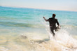Businessman running into the sea