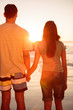 Couple hand in hand walking on the beach